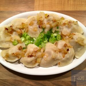 Foto van bord met Vareniki met vlees en uien.