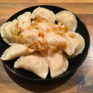 Foto van bord met Vareniki met aardappels en uien.