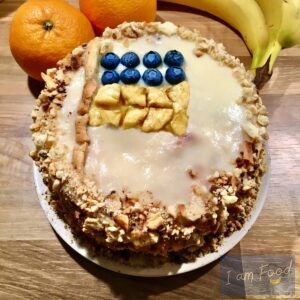 Foto van een taart met stukjes banaan en blauwe bessen gevormd in Oekraïense vlag.